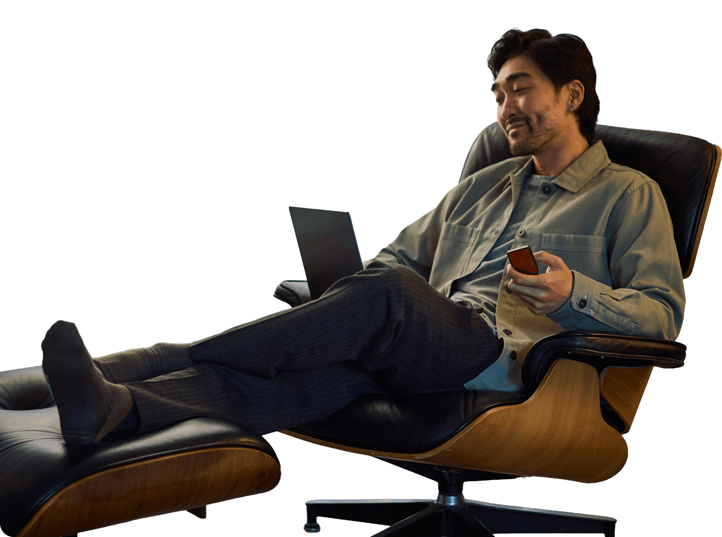 Man relaxing in a chair with a laptop and a Trezor Safe 7 in his hand
